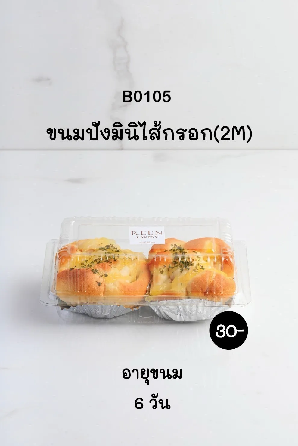 ขนมปังมินิไส้กรอก 2 ชิ้น บรรจุในกล่องพลาสติกใส ท็อปด้วยชีสและโรยหน้าด้วยสมุนไพรแห้ง มีโลโก้ REEN Bakery