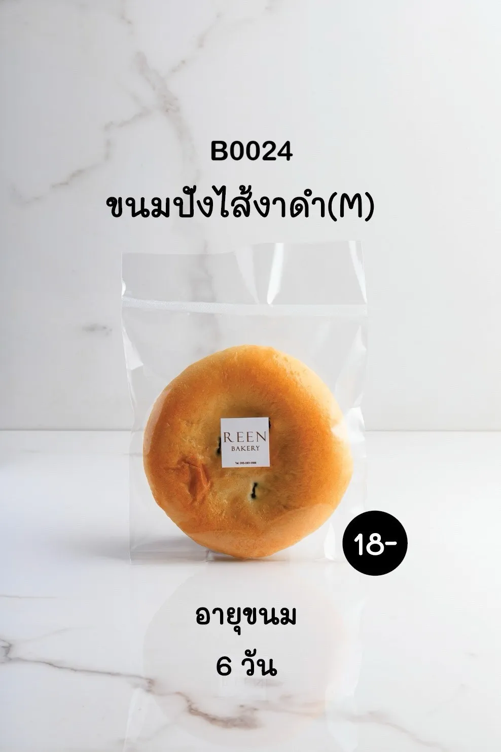 ขนมปังไส้งาดำขนาดกลาง (M) หนึ่งชิ้นบรรจุในถุงพลาสติกใสปิดสนิท มีป้ายโลโก้ REEN BAKERY สีขาวติดอยู่ตรงกลางถุง วางอยู่บนพื้นหินอ่อนสีขาว