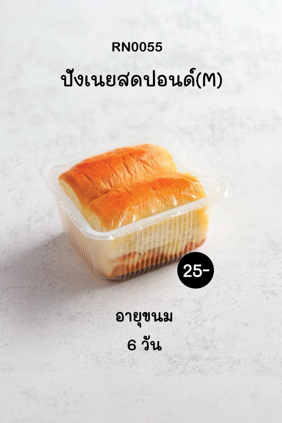 ขนมปังเนยสดสองชิ้นสีเหลืองทองวางอยู่ในกล่องพลาสติกใส บนพื้นผิวสีเทาอ่อน