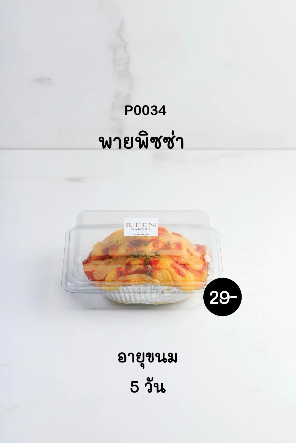 พายพิซซ่าในบรรจุภัณฑ์พลาสติกใสพร้อมทาน วางอยู่บนถาดฟอยล์ มีโลโก้ REEN BAKERY บนกล่อง มองเห็นหน้าพิซซ่ามีชีสและท็อปปิ้งสีแดงเขียวอย่างชัดเจน