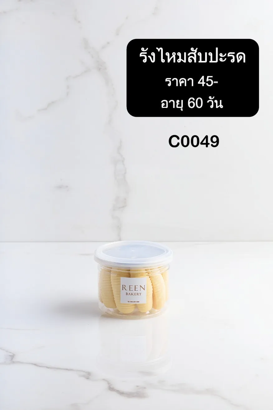 คุกกี้รังไหมสับปะรด REEN Bakery บรรจุในกระปุกพลาสติกใสมีฉลากแบรนด์ วางอยู่บนพื้นผิวหินอ่อนสีขาว